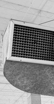 A ceiling-mounted air duct and vent grille, photographed in black and white
